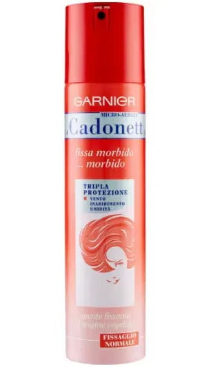 Canister of Garnier Micro-Aerated Cadonett hairspray (250ml) with a pink and silver design. A woman is using the spray to style her hair, with a focus on the flexible hold it offers.